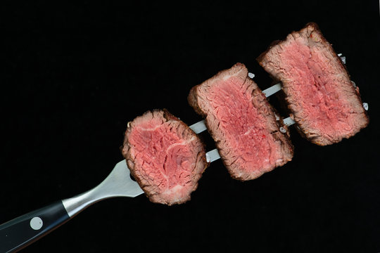 sliced steaks impaled on meat fork