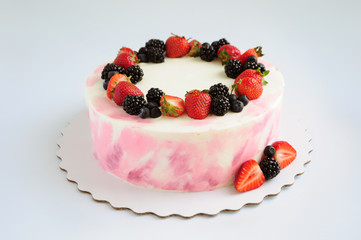 Birthday cream cake with strawberries, blueberries and blackberry on white background. Picture for a menu or a confectionery catalog.