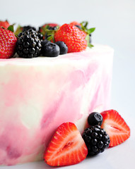Birthday cream cake with strawberries, blueberries and blackberry on white background. close up. Picture for a menu or a confectionery catalog.