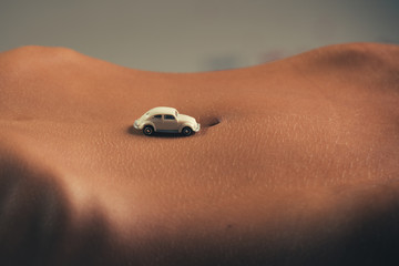 Navel and retro car. Female body and driver of car. Parking and bad roads. Beautiful woman and transport. Gentle skin. Delivery of delicate product. Sexy travel with obstacles, pits on the roads