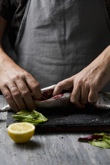 young man cleaning a fresh mackerel