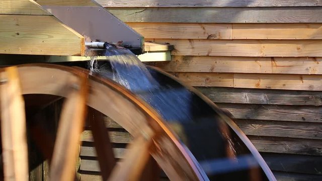 A stream of water falling on the water wheel of the mill