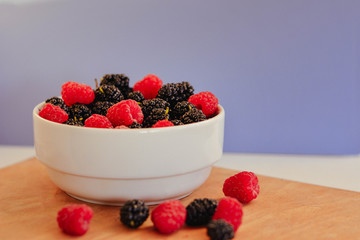 Summer berries in a pialat on wooden background