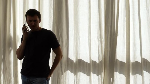 Unhappy young man talking on mobile phone