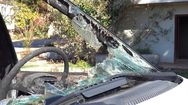 4K Burnt steering wheel and burst windscreen of a car