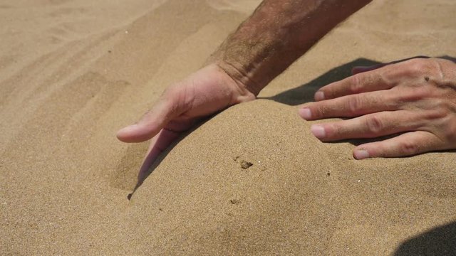 Close up view of sand running through a mans hands
