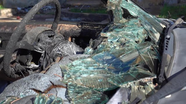 4K Burnt steering wheel and shards of windscreen glass