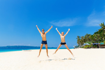 Happy teen boys having fun on the tropical beach. Summer vacation concept