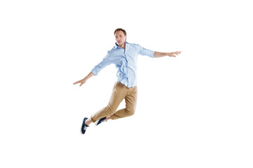 Fototapeta na wymiar young casual man jumping with arms outstretched isolated on white