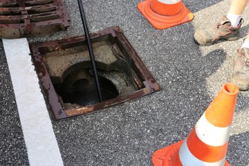 Straßenablauf wird gereinigt (Kanalreinigung)