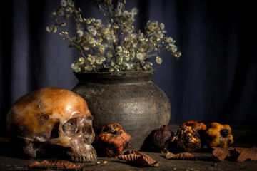 Human skull and flower vase old on wooden background, Still life concept