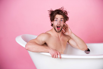 man with muscular body sitting in white bathtub