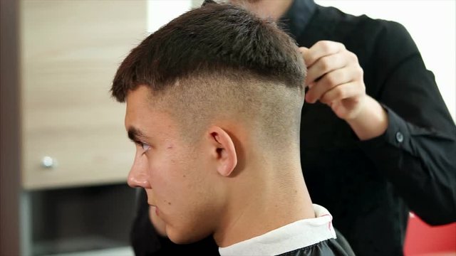 close up shot of the dark-haired head of a man who came to the hairdresser in order to change the haircut and change the image, the client expects a good service