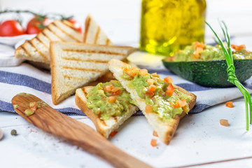 Toast with mashed avocado, olive oil and tomato