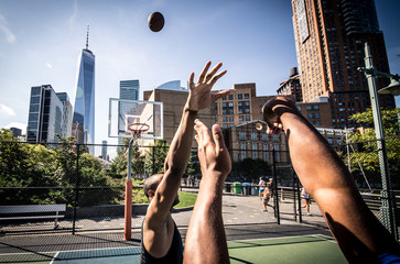 Obraz premium Two street basketball players playing hard on the court