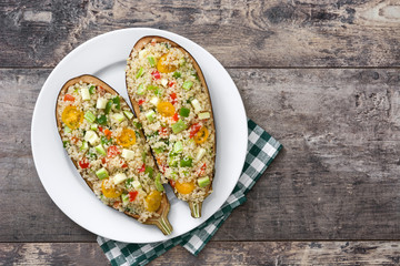 stuffed eggplant with quinoa and vegetables on wooden table - obrazy, fototapety, plakaty