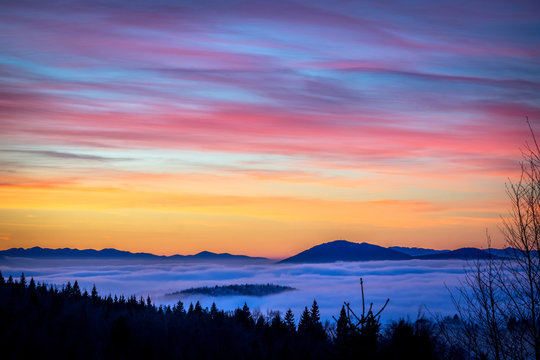Beautiful sunset on the hill above clouds