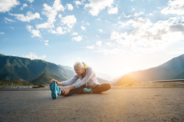 Running stretching. Athlete at the top of the mountain.