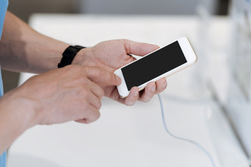 Scaled up look on male hands testing smartphone