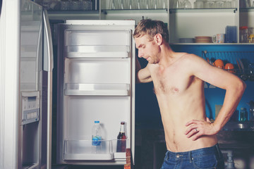 Hungry man opening and looking for food in refrigerator,at the empty refrigerator