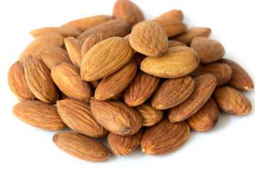 Heap of brown apricot kernels on white background