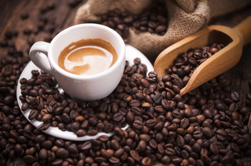 Tasse de café en gros plan sur des grains de café torréfiés foncés