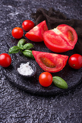 Sliced tomatoes on black background