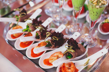 Beautifully decorated catering banquet table with different food snacks and appetizers on corporate christmas birthday party event or wedding celebration