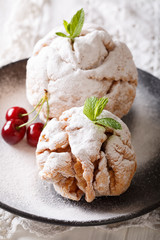 crisp shortbread snowball cake with fresh mint and cherries on a plate macro. Vertical