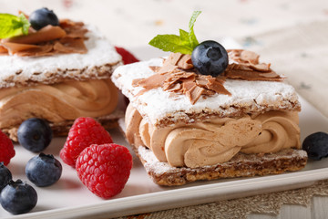 Millefeuille chocolate, decorated with berries and mint macro on a plate. horizontal