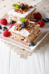 delicious chocolate millefeuille with raspberry and blueberry close-up. Vertical