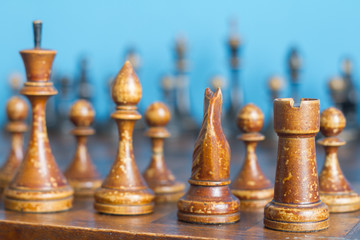 Fototapeta premium Vintage wooden chess pieces on an old chessboard.