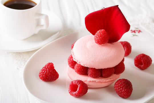 Raspberry macaroon with fresh berries and a cup of coffee close-up on the table. horizontal