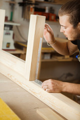 Carpenter does measurements according to project. Woodworker workshop