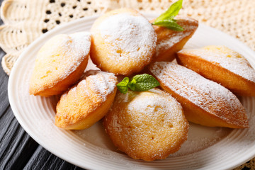 French cookies Madeleine with mint closeup on a plate. Horizontal, classical style