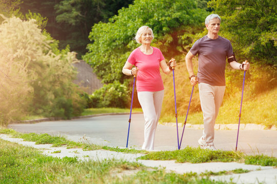 Positive sporty couple walking along the road
