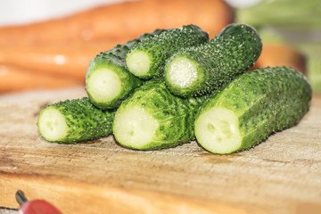 Fresh green cucumber on kitchen wooden cutting board
