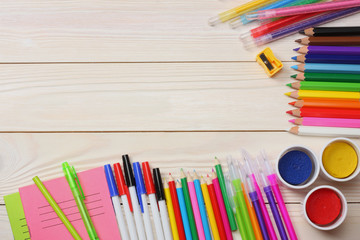 Obraz premium school and office supplies. school background. colored pencils, pen, pains, paper for school and student education on blue wood background. top view with copy space