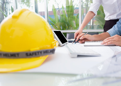 Hands of engineer working with the tool on project drawings background at construction site