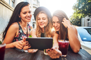 Three young woman at cafe taking selfie 
