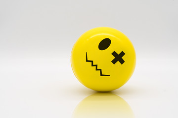 Yellow stress ball rolling on reflection floor