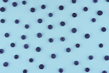 Freshly picked blueberries on blue background.