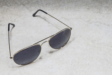 Sun glasses on a stone background
