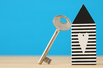 small house model with key over wooden floor. selective focus