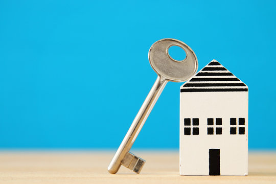 small house model with key over wooden floor. selective focus