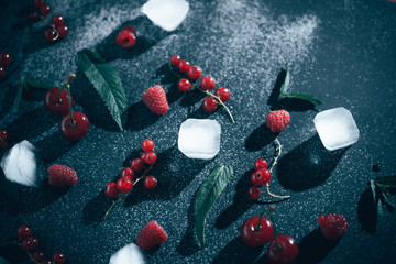 Fresh berries with ice on a black background.