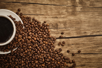 Cup of coffee and coffee beans with wooden table