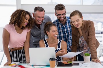 Fototapeta premium Team of executives discussing over document in the office