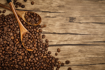Spoon of coffee beans with wooden table