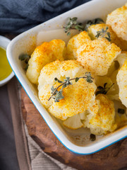 Baked cauliflower with turmeric and marjoram on rustic background. Lunch with vegetables